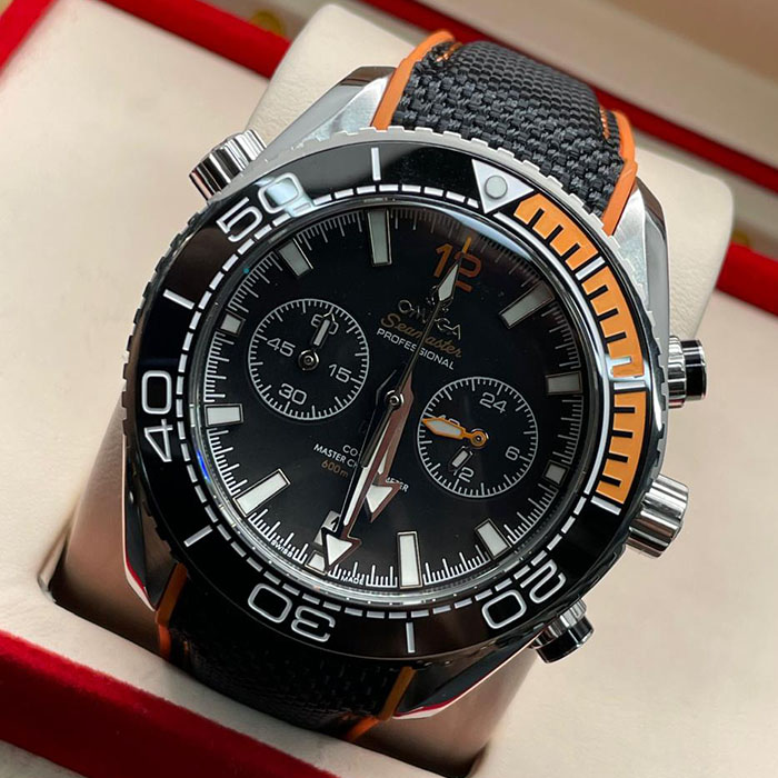 "Reloj Omega Seamaster Co-Axial Master Chronometer con detalles en naranja y correa de tela negra."