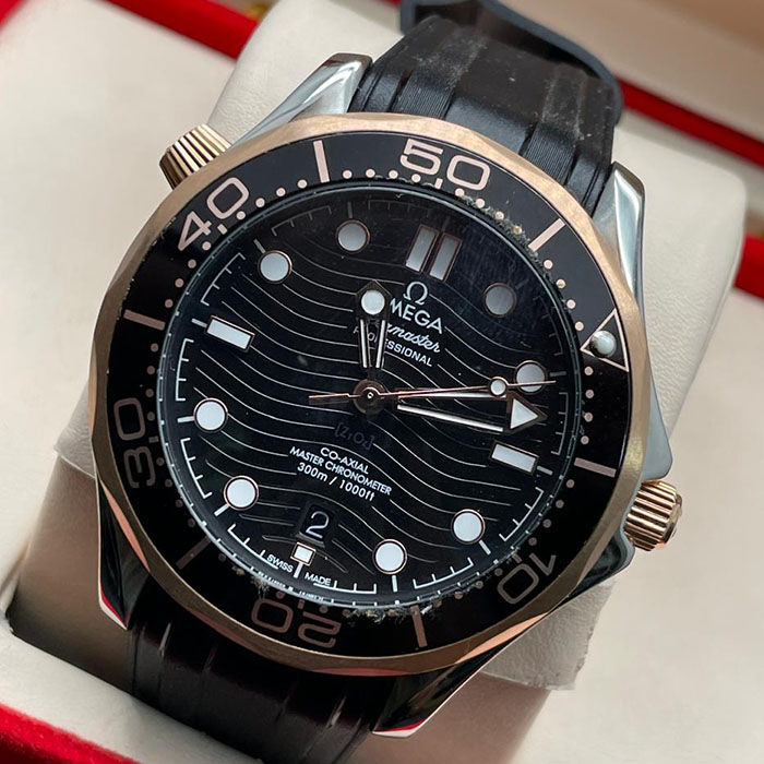 "Reloj Omega Seamaster Co-Axial Master Chronometer con correa negra y detalles en oro rosa, ideal para estilos sofisticados."