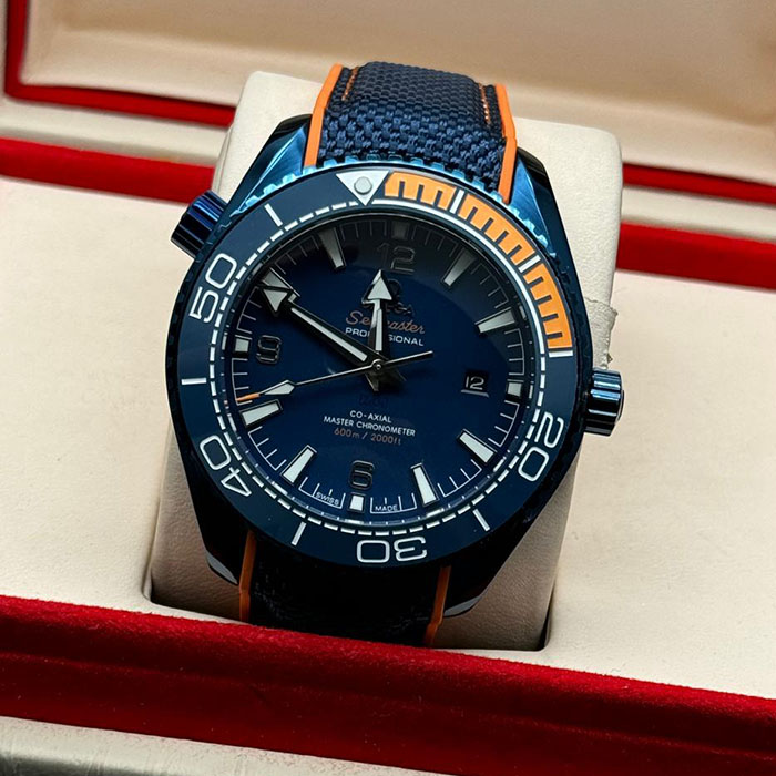 Reloj Omega Seamaster Diver 300M de acero inoxidable con bisel cerámico azul y naranja, perfecto para buceo y deportes acuáticos.